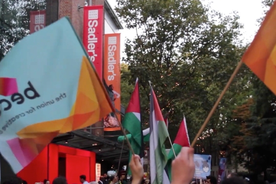 Arts and Culture Workers block on a London Palestine solidarity march. BECTU-Prospect flags can be seen being held, and a large Palestine solidarity banner is held by the group.