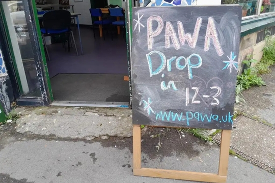 A picture of a sign outside a building reading: "PAWA Drop in 12-3"