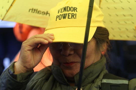Street Vendor wearing a yellow Street Vendor Project cap Street Vendor wearing a yellow Street Vendor Project cap