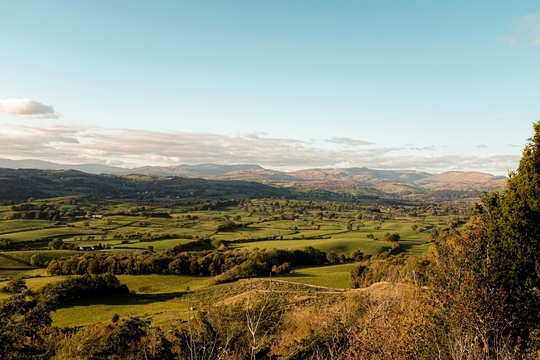 A photo of green hills and rural houses in Cumbria, England.